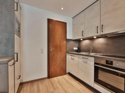 een keuken met witte kasten en een houten deur bij Apartment Chalet Sofie-4 by Interhome in Ischgl