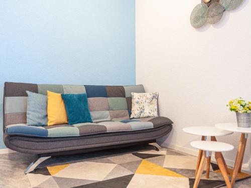 a couch in a living room with colorful pillows on it at Apartment Mont-Fort-29 by Interhome in Siviez