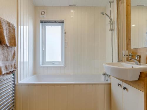 ein Badezimmer mit einer Badewanne und einem Waschbecken in der Unterkunft 2 bed property in Brixham 79989 in Brixham