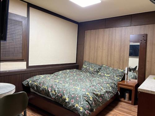 ein Schlafzimmer mit einem Bett in einem Zimmer mit einer Wand in der Unterkunft Brown Hotel in Seoul