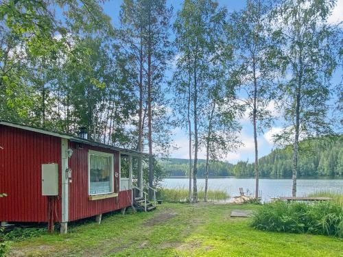 een rode hut met uitzicht op een meer bij Holiday Home Casa rantapirtti by Interhome in Jyväskylä