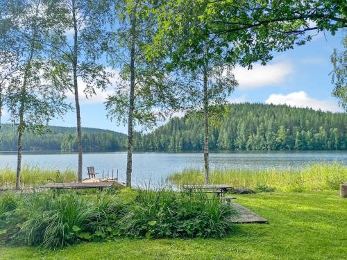 a park with two picnic tables and a lake at Holiday Home Casa rantapirtti by Interhome in Jyväskylä
