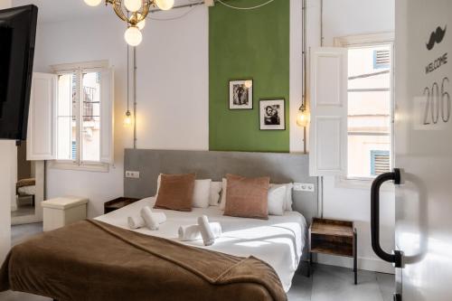 a bedroom with a large white bed and green walls at Antiguo Brondo Selfcheck-in Smart Rooms in Palma de Mallorca