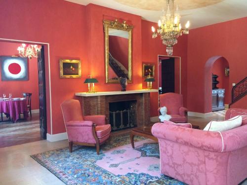a living room with red walls and a fireplace at Demeure de Flore in Lacabarède