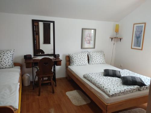 1 dormitorio con cama y escritorio con espejo en Holiday Home Nina Petrinja, en Petrinja