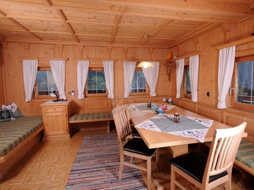 a dining room with a table and chairs and windows at Holiday Home Pfundshof by Interhome in Hippach