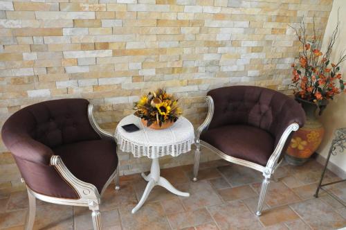 two chairs and a table in front of a brick wall at Masseria Le Terrazze di Serranova in Serranova