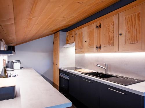 una cocina con fregadero y armarios de madera en Apartment Brotzet Ensoleillé by Interhome, en Gryon