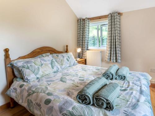 a bedroom with a bed with blue blankets and a window at 2 Bed in Llangenny BN284 in Llangenny