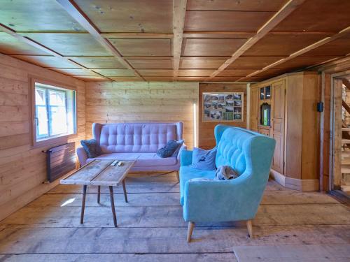a living room with a blue couch and a table at Holiday Home Im Rach by Interhome in Saas