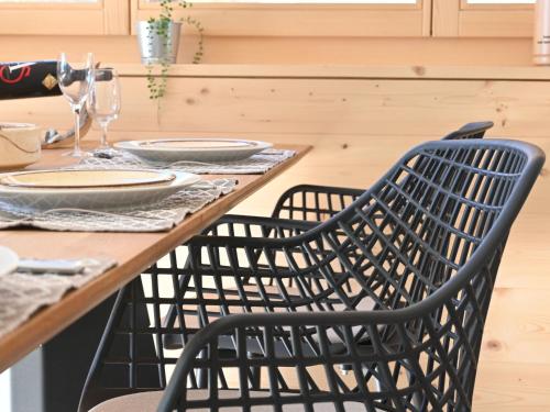 une table en bois avec deux chaises sur une table avec des assiettes dans l'établissement Apartment Clos de Morthey A R 01 by Interhome, à Ovronnaz