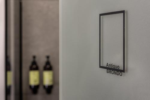 a mirror on a wall with two bottles of wine at Antiguo Brondo Selfcheck-in Smart Rooms in Palma de Mallorca