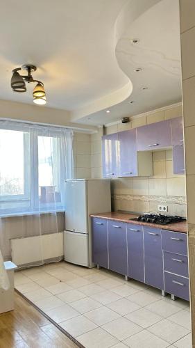 a kitchen with purple cabinets and purple counters at Квартира посуточно in Almaty