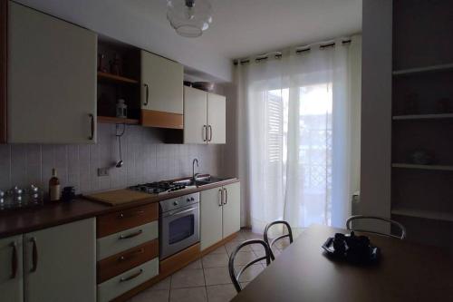 a kitchen with white cabinets and a table with chairs at Casa vacanze Milazzo in Milazzo