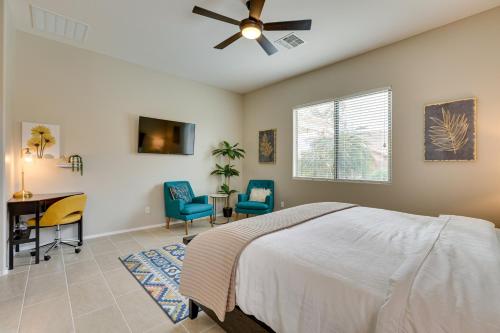 a bedroom with a bed and a desk and chairs at Beautiful Goodyear Home with Pool and Gas Grill! in Goodyear