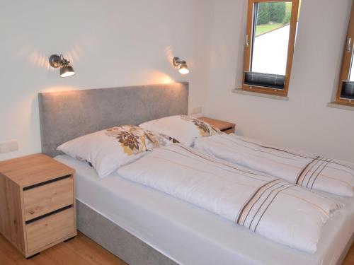 een bed met twee kussens en een nachtkastje ernaast bij Apartment Kapall by Interhome in Obergand