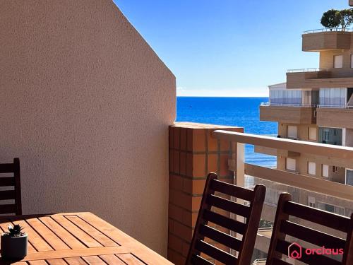 einen Tisch und Stühle auf einem Balkon mit Meerblick in der Unterkunft Marina Sunset 1era línea in Oropesa del Mar