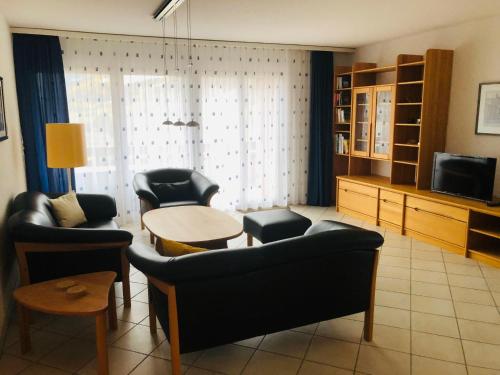 - un salon avec des chaises, une table et une télévision dans l'établissement Apartment Edelweiss A-4 by Interhome, à Loèche-les-Bains