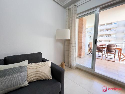 a living room with a couch and a balcony at Marina Sunset 1era línea in Oropesa del Mar