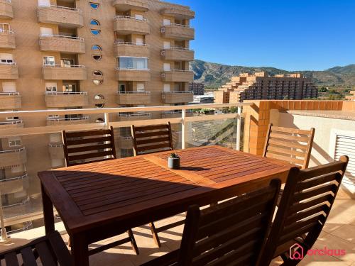 a wooden table and chairs on a balcony at Marina Sunset 1era línea in Oropesa del Mar