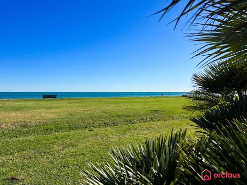 a bench in a field with the ocean in the background at Marina Sunset 1era línea in Oropesa del Mar