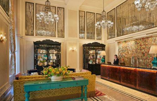 un vestíbulo con bar y una mujer sentada en un escritorio en The Fifth Avenue Hotel, en Nueva York