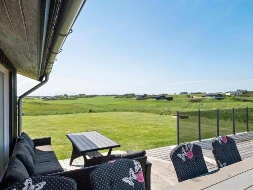 een terras met stoelen en een tafel en een veld bij Holiday Home Månviva - 500m from the sea in NW Jutland by Interhome in Løkken