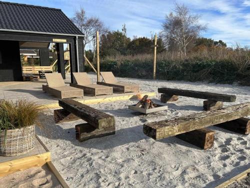 a group of wooden benches sitting in the sand at Holiday Home Grep - 800m from the sea in NE Jutland by Interhome in Strandby