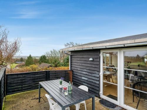 - une table et des chaises sur la terrasse d'une maison dans l'établissement Holiday Home Dimo - 300m to the inlet in The Liim Fiord by Interhome, à Struer