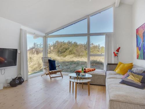 uma sala de estar com um sofá e uma mesa em Holiday Home Annrike - 400m from the sea in NW Jutland by Interhome em Saltum