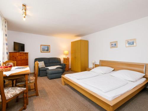 Un dormitorio con una cama y una sala de estar. en Holiday Home Bungalow Nr-4 by Interhome, en Zinnowitz
