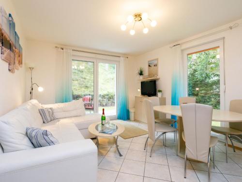 a living room with a white couch and a table at Apartment Meerzeit by Interhome in Trassenheide
