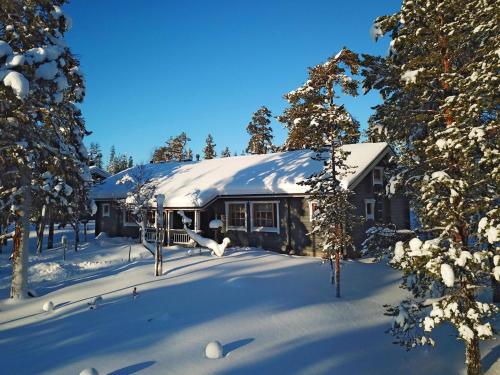 een huis bedekt met sneeuw met bomen ervoor bij Holiday Home Tunturikoivu b1 by Interhome in Saariselkä