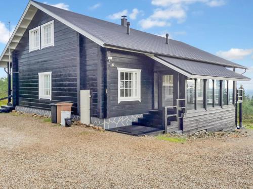 a small black house with a porch and windows at Holiday Home Kontiokota by Interhome in Saariselka