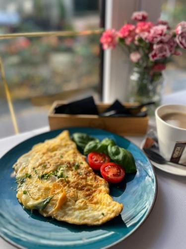 チェンストホヴァにあるWłodary Tennis Juniorのテーブルの上にオムレツと野菜が載った青い皿