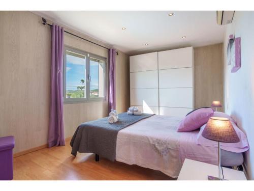 een slaapkamer met een bed en een raam met paarse gordijnen bij Holiday Home Son Alcaines by Interhome in Sineu