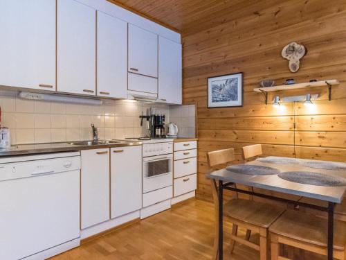 une cuisine avec des placards blancs et une table dans l'établissement Holiday Home Urupää d 17 by Interhome, à Saariselka