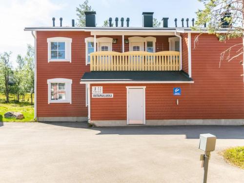 a red house with a balcony on top of it at Holiday Home Outapailakka j 10 by Interhome in Saariselka