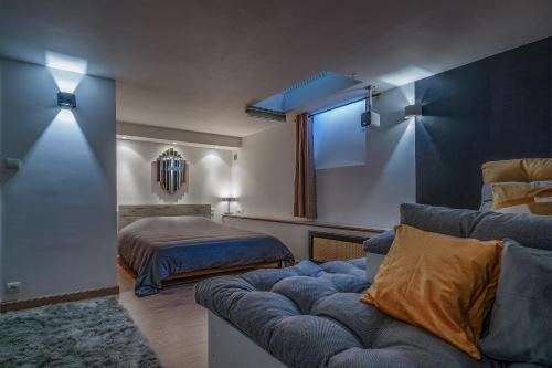a living room with a couch and a bed at L'Evasion - Sauna Jacuzzi Cinema in Tours