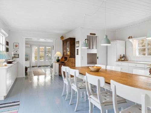 a kitchen and dining room with a wooden table and chairs at Holiday Home Mimi - all inclusive - 800m to the inlet by Interhome in Rørvig