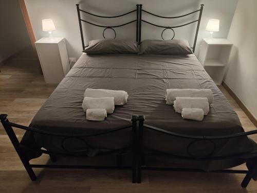 Una gran cama negra con dos almohadas. en [ROME 15min]Modern Accommodation, Airport,Station,LinkHouseCiampino en Ciampino