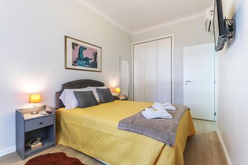 a bedroom with a bed with a yellow bedspread at Vita Portucale ! Moscavide Casa Branca w/ Terrace in Lisbon