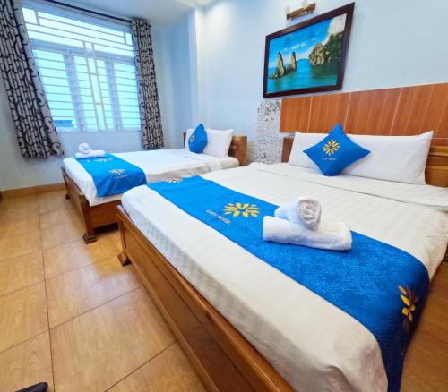 - une chambre avec 2 lits avec des draps bleus et blancs dans l'établissement COZY Hotel HCM, à Hô-Chi-Minh-Ville