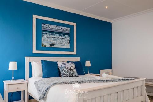 a blue bedroom with a bed with blue walls at SHB Sonvanger in St Helena Bay