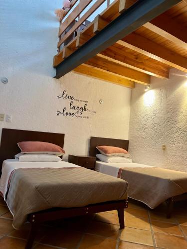 two beds in a room with a loft at VILLA AMATE DORADO in Xochitepec