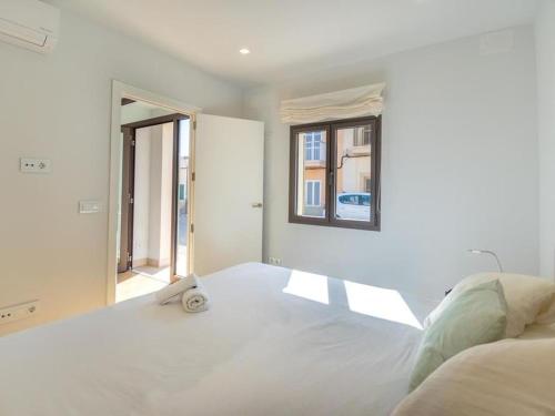a white bedroom with a large bed and a window at Holiday Home Sillot by Interhome in S'Illot