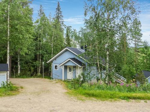 a blue house in the middle of a dirt road at Holiday Home Ukkorinne mökki by Interhome in Hyrynsalmi