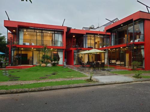 a red building with a lawn in front of it at Seaside Villas An Vien Nha Trang in Nha Trang