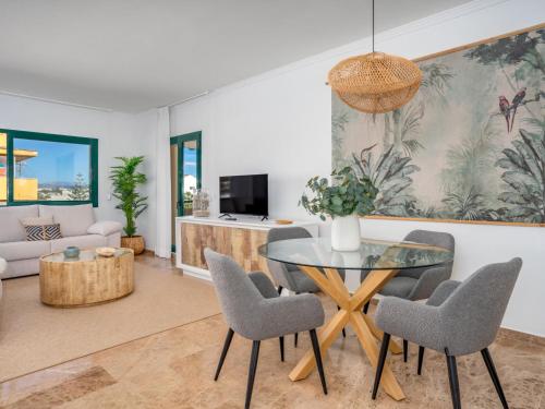 uma sala de estar com uma mesa de vidro e cadeiras em Apartment Los Almendros I by Interhome em Marbella