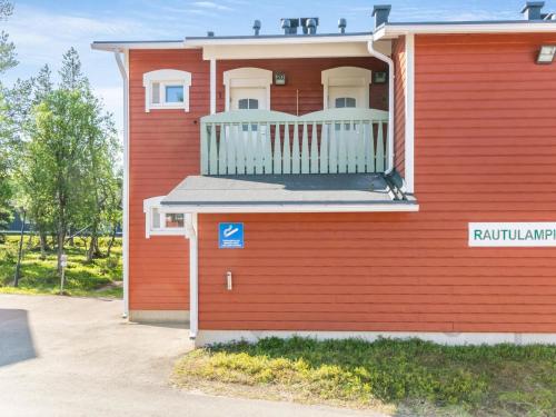 una casa roja con un balcón en el lateral. en Holiday Home Rautulampi g 20 by Interhome, en Saariselkä